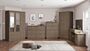 100-102-119_06 - Jamies Furniture Modern kitchen with light wood cabinets, grey countertops, and an island in the center; built-in appliances along the wall.