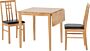 Light wood dining table with three matching wooden chairs around it in a simple room.