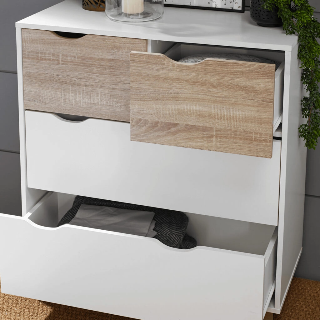 Stockholm-White-Oak-Chest-of-Drawers-2 - Jamies Furniture White dresser with wood-grain front drawers; one top drawer open showing clothes, large bottom drawer open with clothing, plant on top.