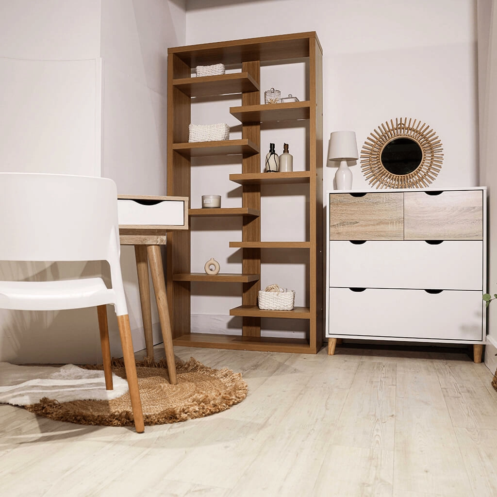 Stockholm-White-Oak-Chest-of-Drawers-4 - Jamies Furniture Tall wooden open-shelf bookcase with decorative items in a minimalist room, flanked by a white dresser with a sunburst mirror on top.